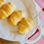 Crescent rolls filled with shredded chicken and cream cheese on a serving tray for a delicious appetizer.