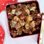 An overhead picture of a Moose Munch Recipe in a red tin with a lid on the side.