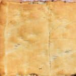 An overhead picture of a Sausage Casserole Recipe in a glass dish on top of a wood pallet.