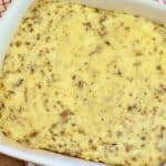 Grit and Sausage Casserole in a 9x13 inch casserole dish on top of a gingham napkin and wood pallet.